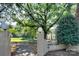 Myrtle Square entrance featuring a stone wall, lush greenery, and mature trees providing ample shade at 1121 Myrtle Ave # 24, Charlotte, NC 28203