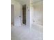 Well-lit bathroom featuring a white soaking tub with shower and glass-enclosed shower, complemented by mosaic tile flooring at 11215 Idlewild Rd, Matthews, NC 28105