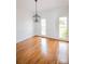 Bright dining room featuring hardwood floors, modern chandelier, and large windows at 11215 Idlewild Rd, Matthews, NC 28105