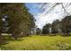 Expansive front lawn with mature trees and white perimeter fence at 11215 Idlewild Rd, Matthews, NC 28105