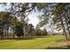 Lush, green front lawn enclosed by a white fence and framed by mature trees at 11215 Idlewild Rd, Matthews, NC 28105