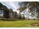 Scenic lot view with mature trees, manicured lawn, and white perimeter fencing at 11215 Idlewild Rd, Matthews, NC 28105