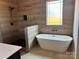 Stylish bathroom featuring a freestanding tub, walk-in shower, and wood-look tile at 1370 Coppergate Dr, Salisbury, NC 28147
