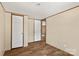 A bedroom with wood-look floors, paneled walls, white doors and trim at 141 Lakewind Dr, Mooresville, NC 28115