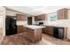 Bright kitchen with wood cabinets, island, and black appliances, offering a functional cooking space at 141 Lakewind Dr, Mooresville, NC 28115