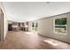 Spacious living room featuring wood-look flooring and abundant natural light, connecting seamlessly to the kitchen and outdoor deck at 141 Lakewind Dr, Mooresville, NC 28115