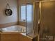 Bathroom with large soaking tub, corner window, and glass enclosed shower stall at 14117 Hiawatha Ct, Huntersville, NC 28078