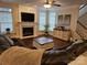 Comfortable living room featuring a fireplace, ceiling fan, a large sofa, and plenty of natural light at 14117 Hiawatha Ct, Huntersville, NC 28078