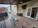 Covered wooden patio showcasing access to a kitchen with furniture and a view of the backyard at 14117 Hiawatha Ct, Huntersville, NC 28078