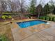 Backyard pool featuring a stamped concrete surround, metal handrails, and mature landscaping at 14117 Hiawatha Ct, Huntersville, NC 28078