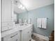 Bright bathroom featuring a marble countertop, vanity with storage, and a large, well-lit mirror at 1623 Geneva Ct, Charlotte, NC 28209