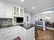 Well-lit kitchen with white cabinetry, granite countertops, and a cozy breakfast bar with seating at 1623 Geneva Ct, Charlotte, NC 28209