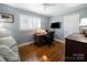 Home office with hardwood floors, a mounted TV, and a comfortable desk and chair setup at 1623 Geneva Ct, Charlotte, NC 28209