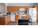 Cozy kitchen featuring wood cabinets, white appliances, and eye-catching tiled backsplash at 2012 Oakstone Dr, Monroe, NC 28110