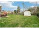 Back yard with lush green grass, a charming patio area, and a storage shed for outdoor convenience at 205 Cowboys Cir, Rock Hill, SC 29732