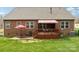 View of backyard with a red brick house, deck, red umbrella, and patio at 205 Cowboys Cir, Rock Hill, SC 29732