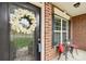 Close-up of a charming front porch features a decorative wreath on the front door and cozy seating area at 205 Cowboys Cir, Rock Hill, SC 29732