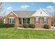 Charming brick home featuring a manicured lawn and bushes, paired with classic black shutters at 205 Cowboys Cir, Rock Hill, SC 29732