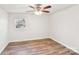 Bedroom with a ceiling fan, natural light, and wood-look floors overlooking the neighborhood at 2611 Rolling Hills Dr, Monroe, NC 28110