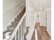 Bright hallway featuring hardwood floors, stairs with white railing, and a view to the bathroom at 2611 Rolling Hills Dr, Monroe, NC 28110