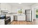 Bright kitchen featuring stainless steel appliances, white cabinets, and a window over the sink at 2611 Rolling Hills Dr, Monroe, NC 28110