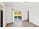 Bright living room featuring wood-look floors, sliding glass doors to the backyard, and neutral paint at 2611 Rolling Hills Dr, Monroe, NC 28110