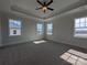 Bright, carpeted bedroom featuring a tray ceiling, ceiling fan, and three large windows at 267 Luray Way # 445, Rock Hill, SC 29730