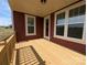 Covered porch area featuring natural wood decking, red paneled siding, white trim, and a ceiling light at 267 Luray Way # 445, Rock Hill, SC 29730