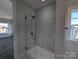 A sleek, glass-enclosed shower with marble-look tile and chrome hardware is luxurious and modern at 275 Luray Way # 447, Rock Hill, SC 29730