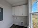 Convenient laundry room with white cabinets, washer/dryer hookups, and a window for natural light at 275 Luray Way # 447, Rock Hill, SC 29730