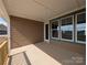 Covered patio featuring brown horizontal siding, blue trimmed windows, a screen door, and ample space at 275 Luray Way # 447, Rock Hill, SC 29730