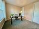 Neutral carpeted room with a window, desk and a black adjustable height desk at 278 W Waterlynn Rd, Mooresville, NC 28117