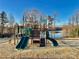 Community playground featuring a variety of climbing and sliding activities set against a serene lake backdrop at 278 W Waterlynn Rd, Mooresville, NC 28117