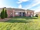 Brick home with backyard featuring green grass and an enclosed patio at 2802 Santiago Cir, Monroe, NC 28110