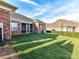 Green backyard with brick home and covered patio at 2802 Santiago Cir, Monroe, NC 28110