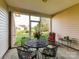 Relaxing screened patio with a metal table, floral chairs, and peaceful backyard view at 2802 Santiago Cir, Monroe, NC 28110