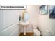 Clean powder room with a pedestal sink, toilet, wood floors, and modern decor at 3018 Sassafras Trl, Gastonia, NC 28056