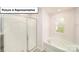 A well-lit bathroom with a glass-enclosed shower and a separate soaking tub under a window at 3020 Sassafras Trl, Gastonia, NC 28056