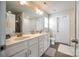 Bright bathroom featuring double vanity with white cabinets, a large mirror, and tiled floors at 317 Praline Way, Fort Mill, SC 29715