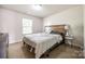 Cozy bedroom featuring neutral walls, carpet, a wood-accent headboard, and natural light from the window at 317 Praline Way, Fort Mill, SC 29715