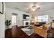 Open living room featuring a fireplace, hardwood flooring, and an adjacent bathroom entrance at 317 Praline Way, Fort Mill, SC 29715