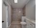 Bathroom featuring a tiled shower with a bench, modern fixtures, and neutral wall colors at 35494 Dry Rd, Albemarle, NC 28001