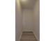 Neutral walk-in closet with wood-look flooring, base molding, and a single light fixture overhead at 35494 Dry Rd, Albemarle, NC 28001