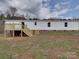 View of house featuring a wooden deck in a yard with sparse grass and visible brick foundation at 35494 Dry Rd, Albemarle, NC 28001