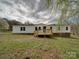 A charming house with a wooden deck is surrounded by a vibrant green lawn and features an inviting entrance at 35494 Dry Rd, Albemarle, NC 28001