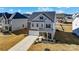 Attractive two-story home with gray siding, brick details, a two-car garage, and a covered front porch at 4208 Stream Dale Nw Cir, Concord, NC 28027