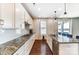 Modern kitchen with white cabinets, granite countertops, stainless steel appliances, and hardwood floors at 4208 Stream Dale Nw Cir, Concord, NC 28027