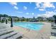 Outdoor community pool with clear blue water, lounge chairs, and umbrellas for relaxation at 4208 Stream Dale Nw Cir, Concord, NC 28027