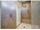 Modern bathroom shower featuring gray tile walls and a built-in bench at 4208 Stream Dale Nw Cir, Concord, NC 28027