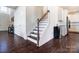 Stairway with wooden steps and white railing, adjacent to the kitchen and entryway at 4208 Stream Dale Nw Cir, Concord, NC 28027